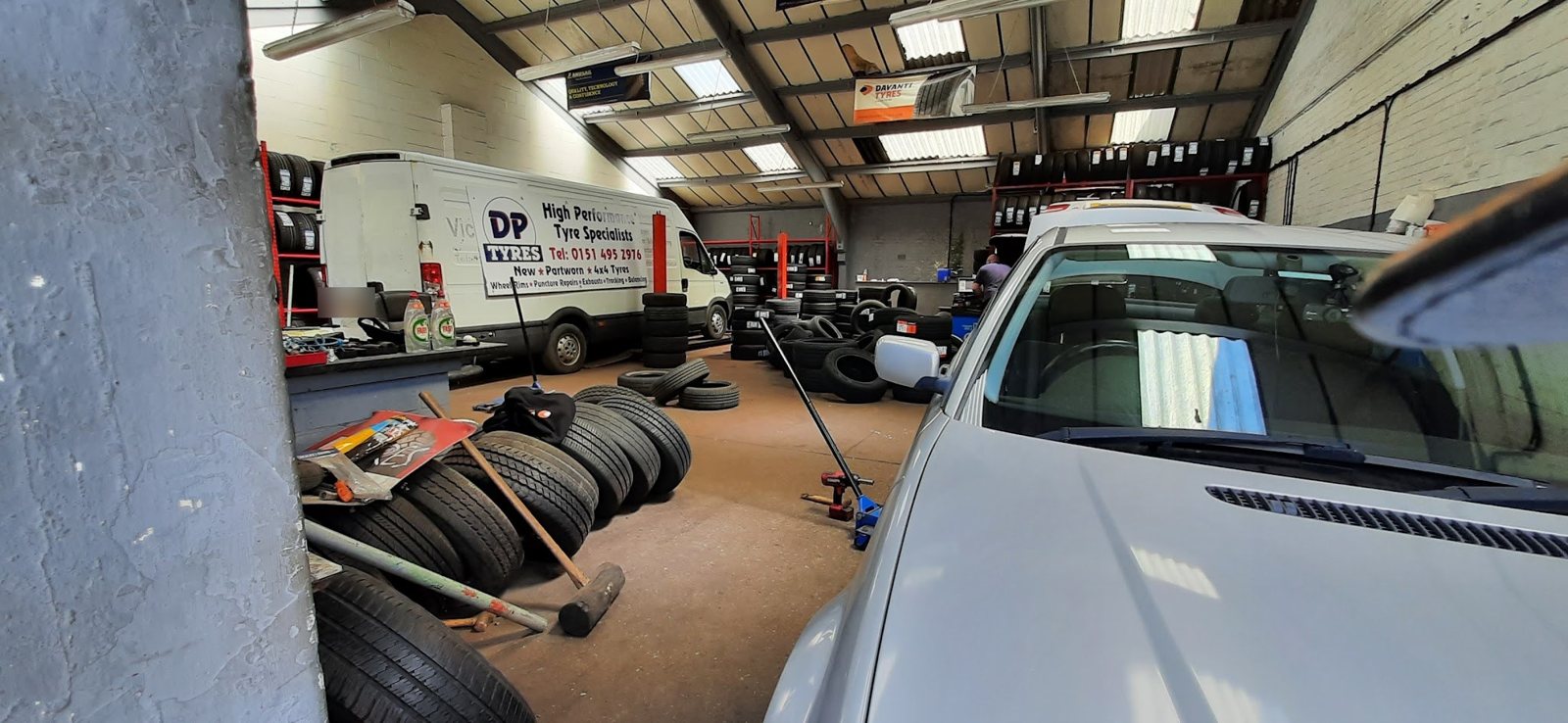 Inside the workshop: racks of tyres and the D P Tyres van, High Performance Tyre Specialists
